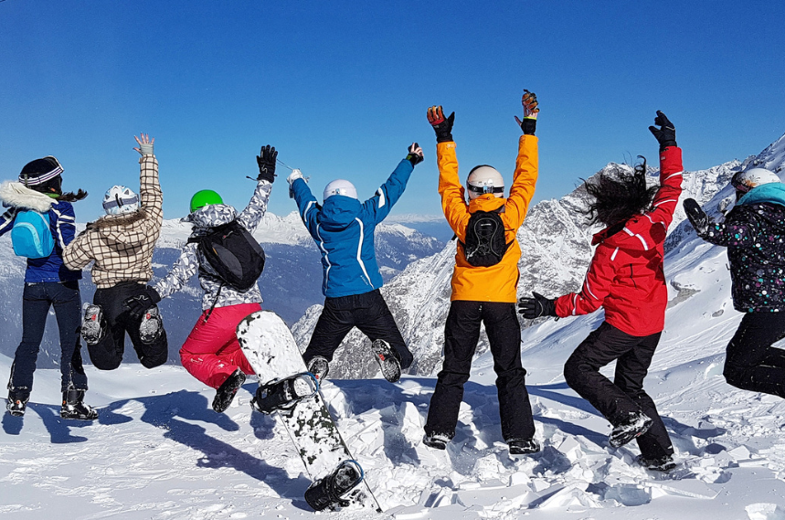 Image of a group of students out on ski slopes, with snowy mountains in the background